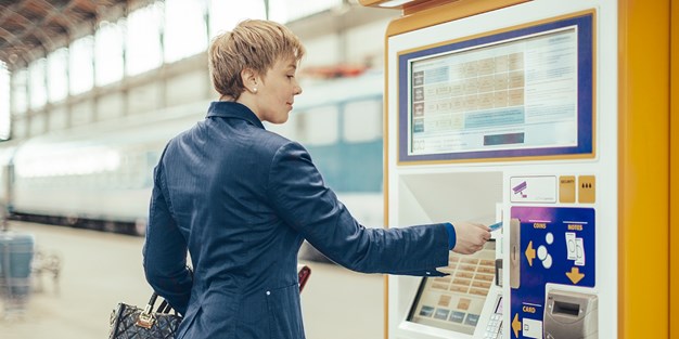 En person som köper biljett ur en automat. Foto