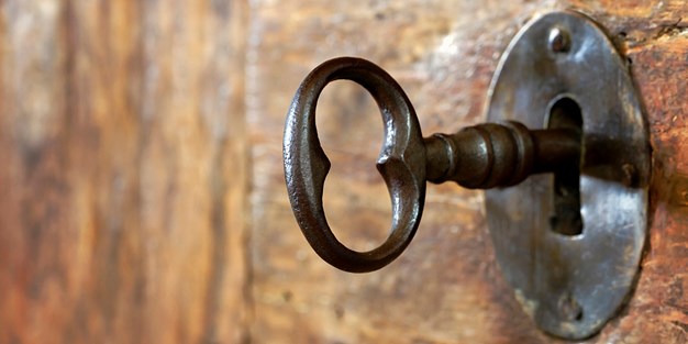 En gammel nøkkel i en dør. Foto