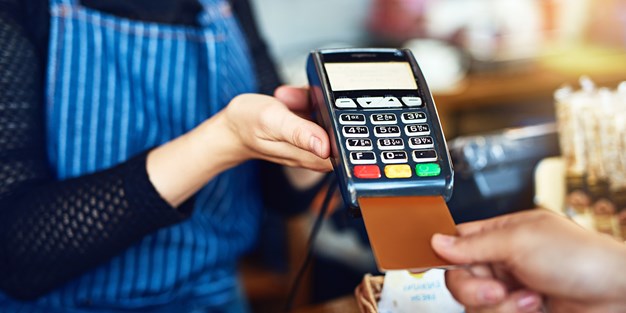 A person pays with a debit card. Photo