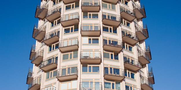 Ett bostadshus med många lägenheter och balkonger. Foto