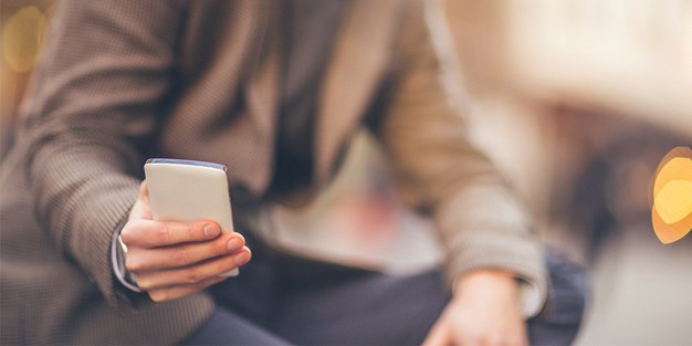 A man sitting with a mobile phone. Photo