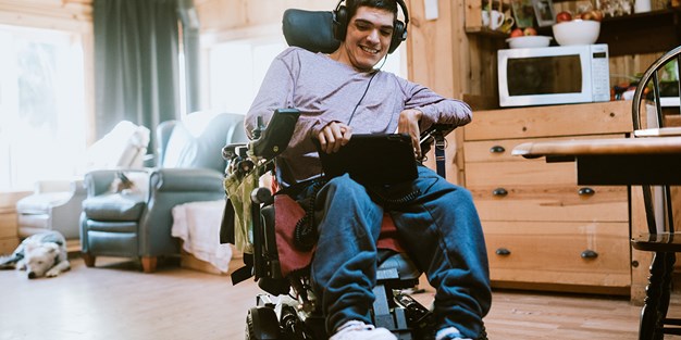 A person in a wheelchair using a tablet, photo.
